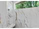 Detail of elegant shower with marble tile and dual shower heads at 213 Westhampton Dr, Pittsboro, NC 27312