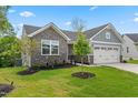 Beautiful home with stone accents, lush green lawn, and professional landscaping at 164 Clove Hitch Ln, Fuquay Varina, NC 27526