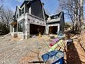 Exterior view of a house under construction, highlighting the two-car garage, siding and open framing at 508 Northwood Dr, Raleigh, NC 27609