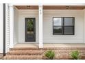 Inviting front porch with brick steps, decorative columns, and a stylish front door for a warm welcome at 7327 Shawan Rd, Wendell, NC 27591