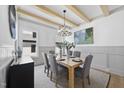 Elegant dining area featuring natural wood beams, chandelier and six upholstered chairs at 5305 Dixon Dr, Raleigh, NC 27609
