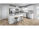 Bright kitchen with white cabinets, stainless steel appliances, and a granite island with seating at 356 N Coral Bells Way Way, Four Oaks, NC 27524