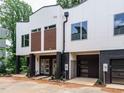 Modern townhome exterior showcasing the sleek design, private garages, and a well-maintained landscape at 1523 Havenmont Ct, Raleigh, NC 27608