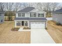 Aerial view of a two-story home with gray siding, a two-car garage, and an expansive driveway at 138 New Twin Branch Ct, Smithfield, NC 27577