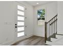 Bright entryway features a modern door with glass panels, staircase with dark railings, and wood flooring at 2329 E Main St, Durham, NC 27703