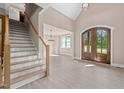 Inviting entryway features a staircase, light hardwood floors, and a front door with glass panels at 4268 Jacks Creek Trl, Burlington, NC 27215