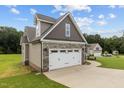 Attached garage showcasing the exterior finishes of stone and complementary siding at 75 Woodbark Cv # 10, Willow Springs, NC 27592