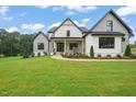 Charming two-story home with black trim, a covered porch, and lush green lawn at 1804 Stream Manor Ct, Wake Forest, NC 27587