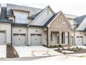 Charming townhome showcasing a two-car garage, brick accents, and manicured landscaping at 804 Ambercrest Place, Durham, NC 27705