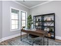 Bright home office featuring a desk, chair, bookshelf, and large windows for natural light at 804 Ambercrest Place, Durham, NC 27705