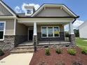 Inviting front porch with stone accents and black wrought iron railing at 103 Sage Ln # 009, Four Oaks, NC 27524