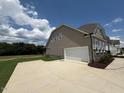 This home features an attached two car garage with a concrete driveway and lush green lawn at 103 Sage Ln # 009, Four Oaks, NC 27524