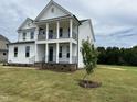 Beautiful new home boasting a double porch, well manicured lawn and fresh landscaping at 123 Sage Ln # 010, Four Oaks, NC 27524