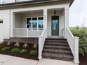 Inviting front porch featuring brick stairs and a green front door at 6059 Scalybark Road, Durham, NC 27712