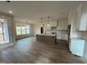 Bright kitchen with an island, white cabinets, and access to a deck at 6060 Scalybark Rd, Durham, NC 27712