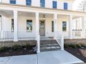 Inviting front porch with white columns and gray door at 6063 Scalybark Road, Durham, NC 27712