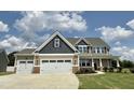 Charming two-story home with a three-car garage and front porch with stone accents at 234 Crystal Springs Way, Benson, NC 27504