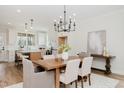 Elegant dining area with wood table and modern chandelier next to open-concept kitchen and island seating at 30 Imperial Oaks Ct, Youngsville, NC 27596