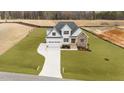 New construction home boasts a two-car garage and a mix of white siding and stone accents at 125 Cotton Fields Ln # 26, Fuquay Varina, NC 27526