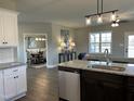 Open concept kitchen features stainless appliances, granite counters, kitchen island, and adjoins a dining room at 98 Prency Ln, Middlesex, NC 27557