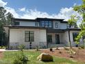 Modern home featuring light gray siding and stone accents, surrounded by fresh landscaping and a manicured lawn at 67 Quail Pt, Pittsboro, NC 27312