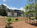 Contemporary home showcasing modern siding and stonework with professional landscaping and mature trees at 67 Quail Pt, Pittsboro, NC 27312