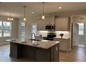Bright kitchen features stainless appliances, granite countertops, and a spacious central island with seating at 27 Prency Ln, Middlesex, NC 27557
