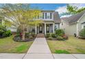 Inviting blue two-story home with a charming front porch and meticulously landscaped front yard at 901 Wildflower Ridge Rd, Wake Forest, NC 27587
