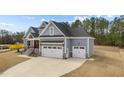 Side view of home showcasing the three-car garage and manicured lawn at 262 Hook Dr # 12, Fuquay Varina, NC 27526