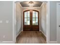 Inviting entryway with arched doorway, double glass doors and wood floors at 100 Old Garden Ln, Youngsville, NC 27596