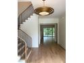 Welcoming foyer with hardwood floors, staircase with black iron railing, and modern lighting fixture at 2227 Wheeler Rd, Raleigh, NC 27607