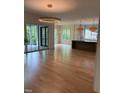 Open living space with hardwood floors, multiple windows, and access to outdoor patio at 2227 Wheeler Rd, Raleigh, NC 27607
