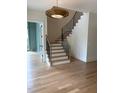 Elegant staircase with wood treads, black iron railings, and decorative lighting overhead at 2227 Wheeler Rd, Raleigh, NC 27607
