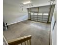 Empty two car garage with a garage door with clear glass panels in the top row at 303 Bishop Ln, Sanford, NC 27330