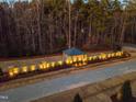 A brick wall with landscape lighting marks the entrance to this wooded community at 279 Westhampton Dr, Pittsboro, NC 27312