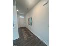 Inviting hallway with modern wood flooring, a decorative rug, and a sleek mirror at 323 Chestnut Oak Ln, Lillington, NC 27546