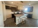 Modern kitchen featuring a large island with seating, granite countertops, and stainless steel appliances at 323 Chestnut Oak Ln, Lillington, NC 27546