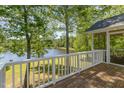 Enjoy stunning lake views from the deck with white railing, surrounded by lush trees at 3309 Westcott Cir, Sanford, NC 27330