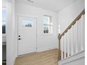 Bright entryway with light wood floors and stairs at 329 Roxboro St, Haw River, NC 27258