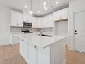Bright kitchen features white cabinets, stainless appliances, and an island with a sink at 814 Barlow Dr, Knightdale, NC 27545