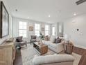 Comfortable living room featuring a plush sofa, two chairs, natural light, and wood-look flooring at 1505 Patchings Ln, Knightdale, NC 27545