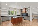 Spacious kitchen featuring hardwood floors, a center island, stainless steel appliances, and ample counter space at 3691 Graham Sherron Rd, Wake Forest, NC 27587