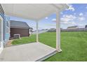 Covered patio overlooking the backyard with grassy areas at 292 Chestnut Oak Ln, Lillington, NC 27546