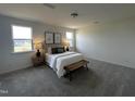 Cozy main bedroom with carpeted floors, two windows, accent wall decor, and a comfortable bed at 191 Robert Howe Dr, Fuquay Varina, NC 27526