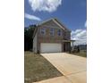 Charming brick two-story home features a large garage and well-manicured front yard at 401 Winding Creek Dr, Lillington, NC 27546