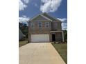 Charming brick two-story home features a large garage and well-manicured front yard at 401 Winding Creek Dr, Lillington, NC 27546