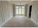 Bright dining room with large windows, decorative molding, and light hardwood floors, perfect for entertaining guests at 4905 Hidden Pasture Way, Zebulon, NC 27597