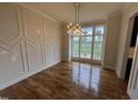 Elegant dining room with decorative molding, modern light fixture, and large windows showing exterior views at 4905 Hidden Pasture Way, Zebulon, NC 27597