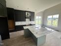 Large kitchen with sleek gray cabinets, a spacious island, and modern finishes awaiting final touches at 4905 Hidden Pasture Way, Zebulon, NC 27597