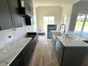 Elegant kitchen featuring an island, black cabinets, marble countertops and stainless steel appliances at 4905 Hidden Pasture Way, Zebulon, NC 27597